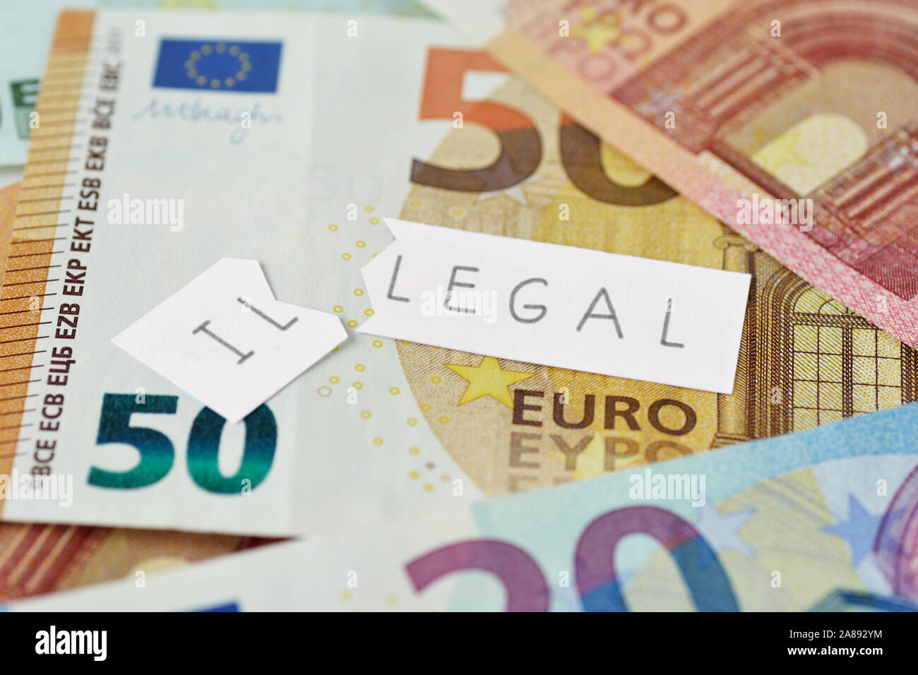 Torn paper note with illegal text on euro banknotes background - Concept of legal and illegal Stock Photo