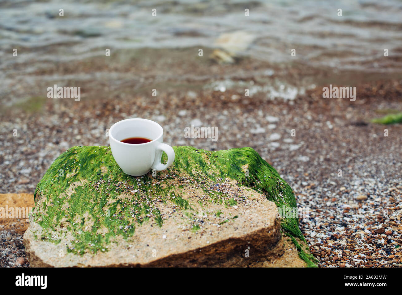 cup of coffee on the sea water and stone background. Sea freshness ...