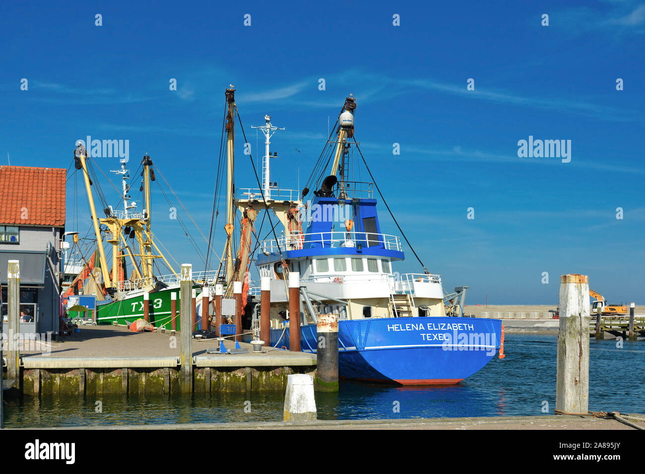 Dutch cutter boat with bottom trawling fishing nets called 'Helena Elizabeth Texel' anchored in Oudenshild harbor on island Texel Stock Photo