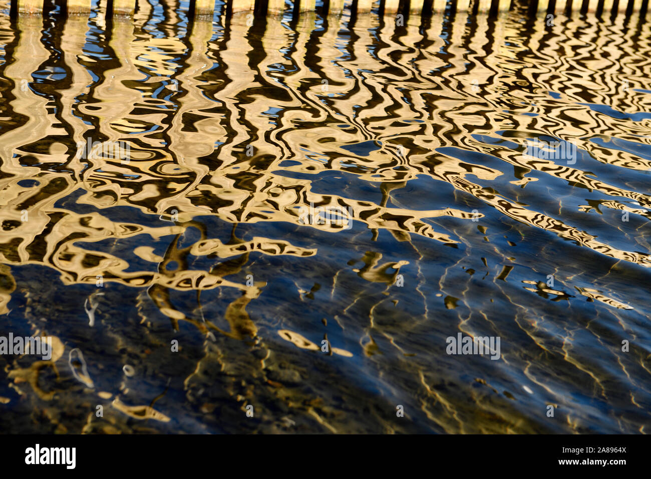 Abstract lines and patterns of wood dock reflected in water of Lake Windermere Waterhead Ambleside Lake District England Stock Photo