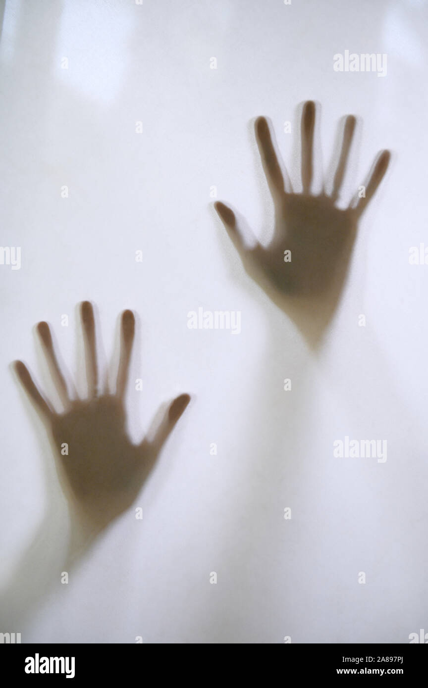 Woman's hands touching frosted glass Stock Photo