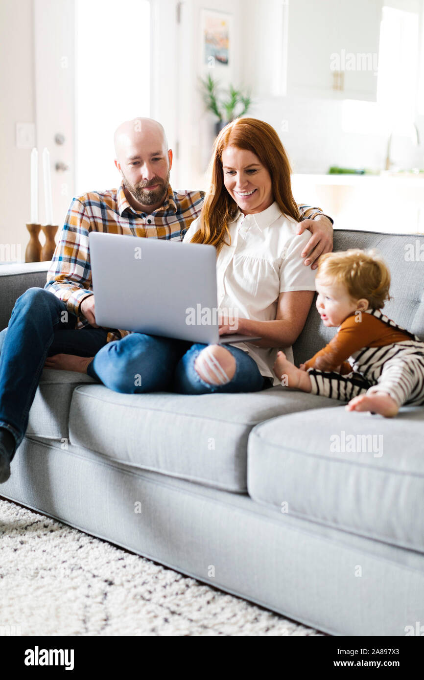 Family using laptop on sofa Stock Photo