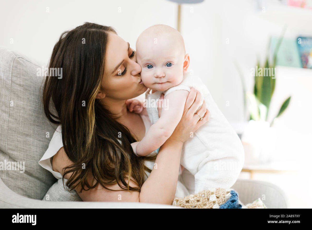 Mother kissing her baby boy's cheek Stock Photo