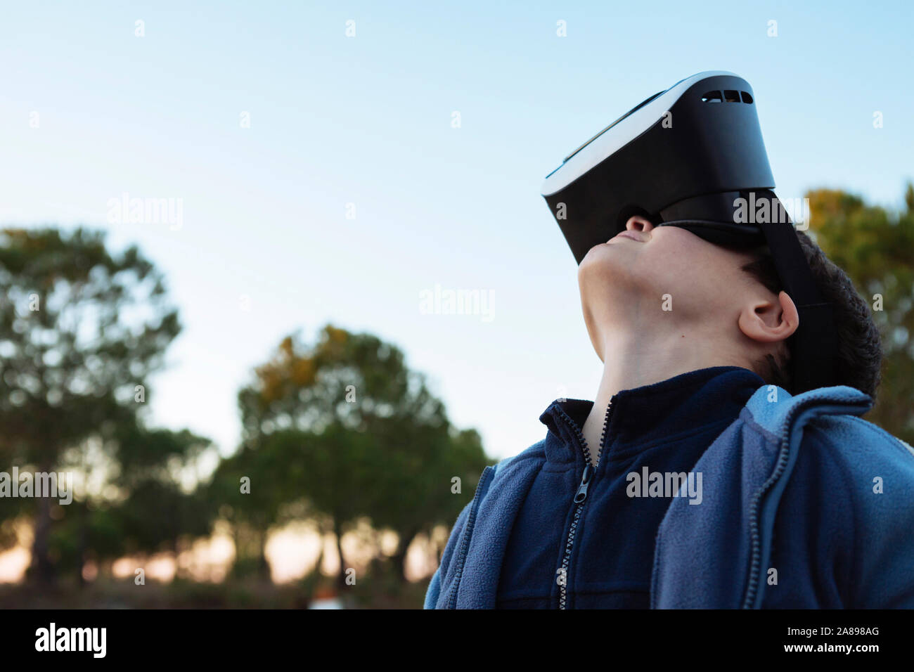 Boy wearing virtual reality simulator outdoors Stock Photo