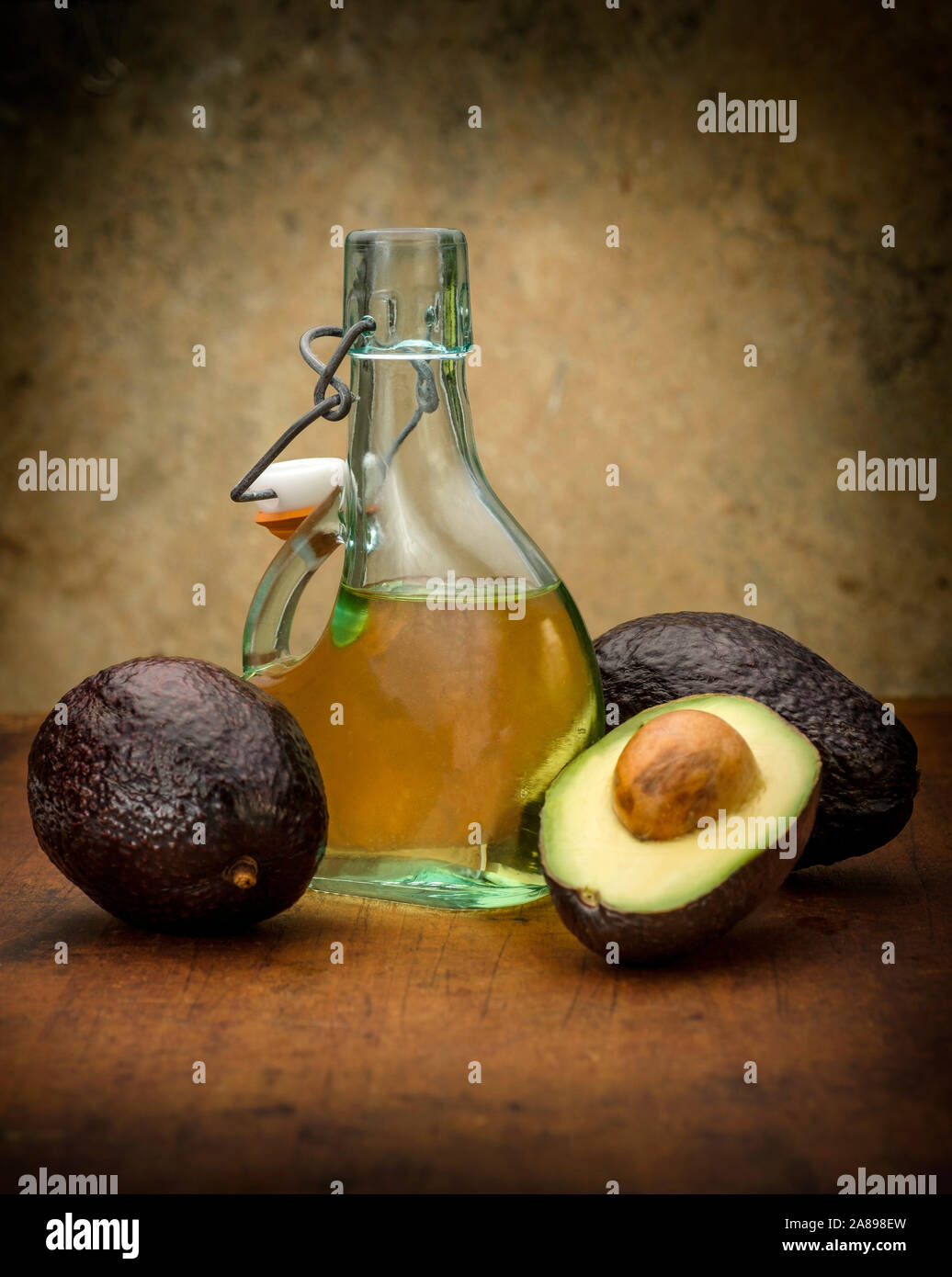 Avocados with bottle of oil Stock Photo Alamy