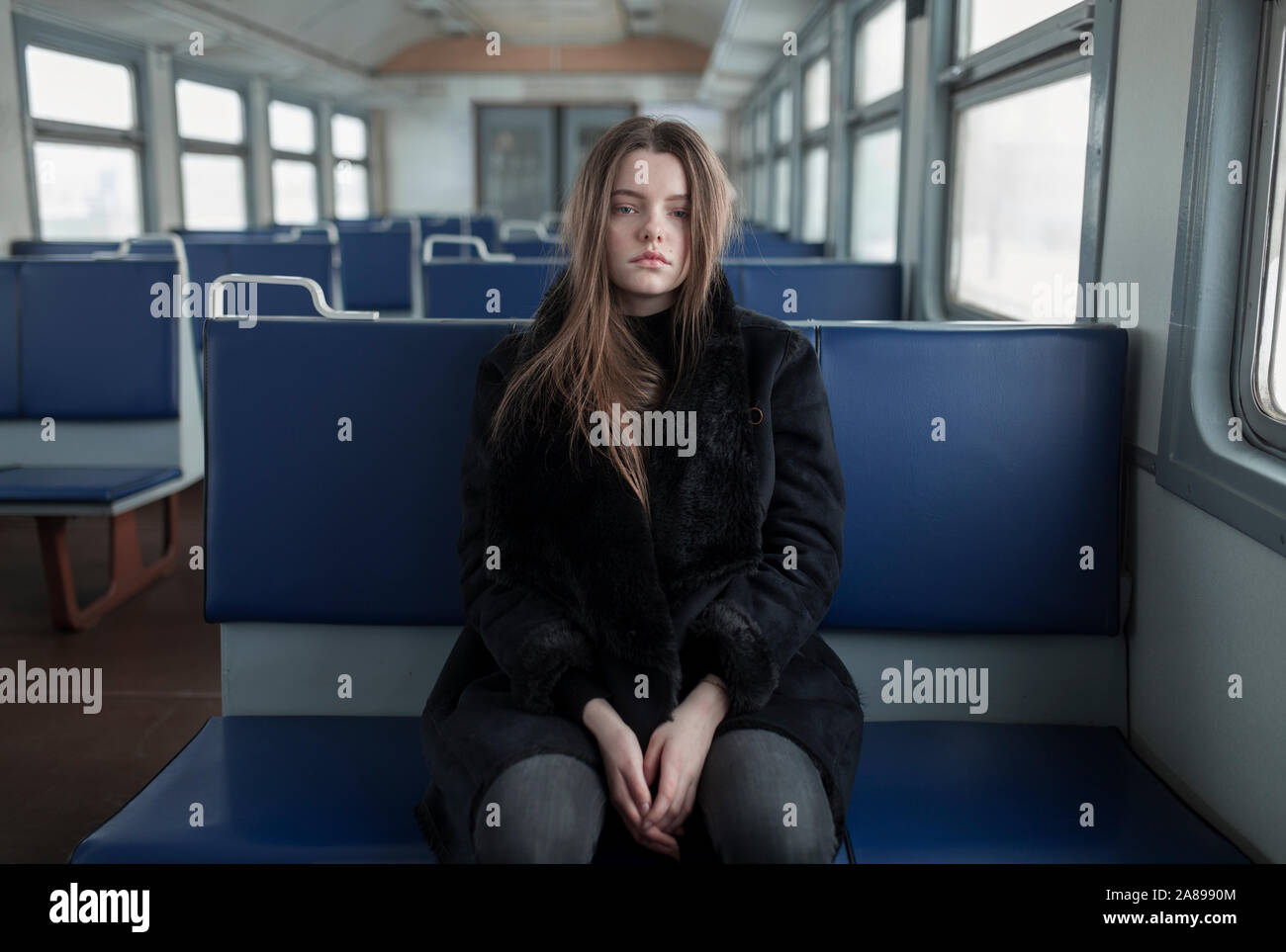 Young woman wearing black fur coat on train Stock Photo - Alamy