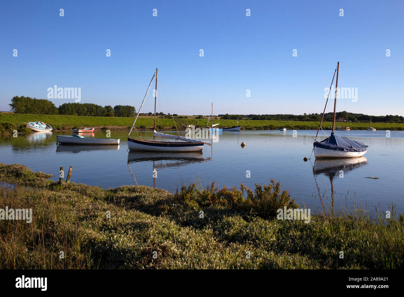 Boats moored at high tide at inlet near Morston Quay,Norfolk,England Stock Photo
