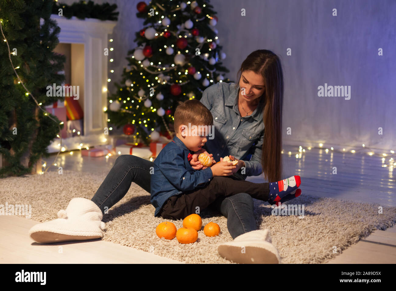Mom and son new year christmas tree gifts Stock Photo - Alamy
