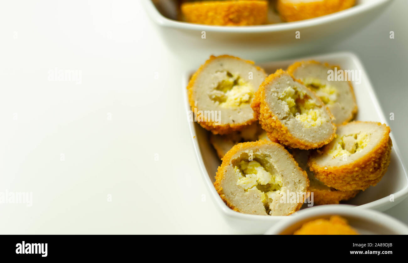 Savory mini scotch eggs in white ceramic bowl, traditional English snack, appetizer Stock Photo