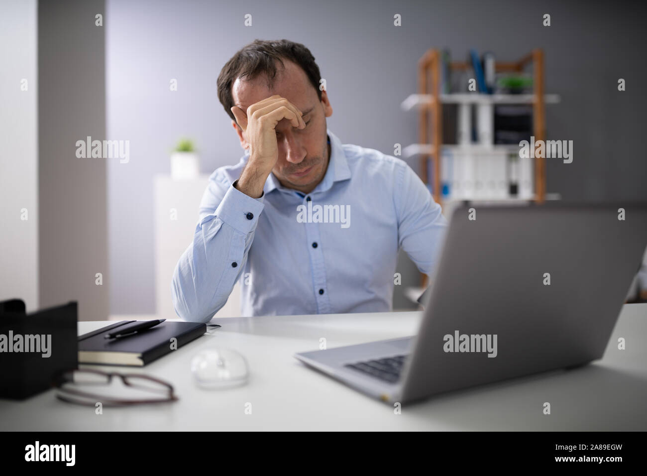 Front View Of A Stressed Businessman Sitting In Office Stock Photo