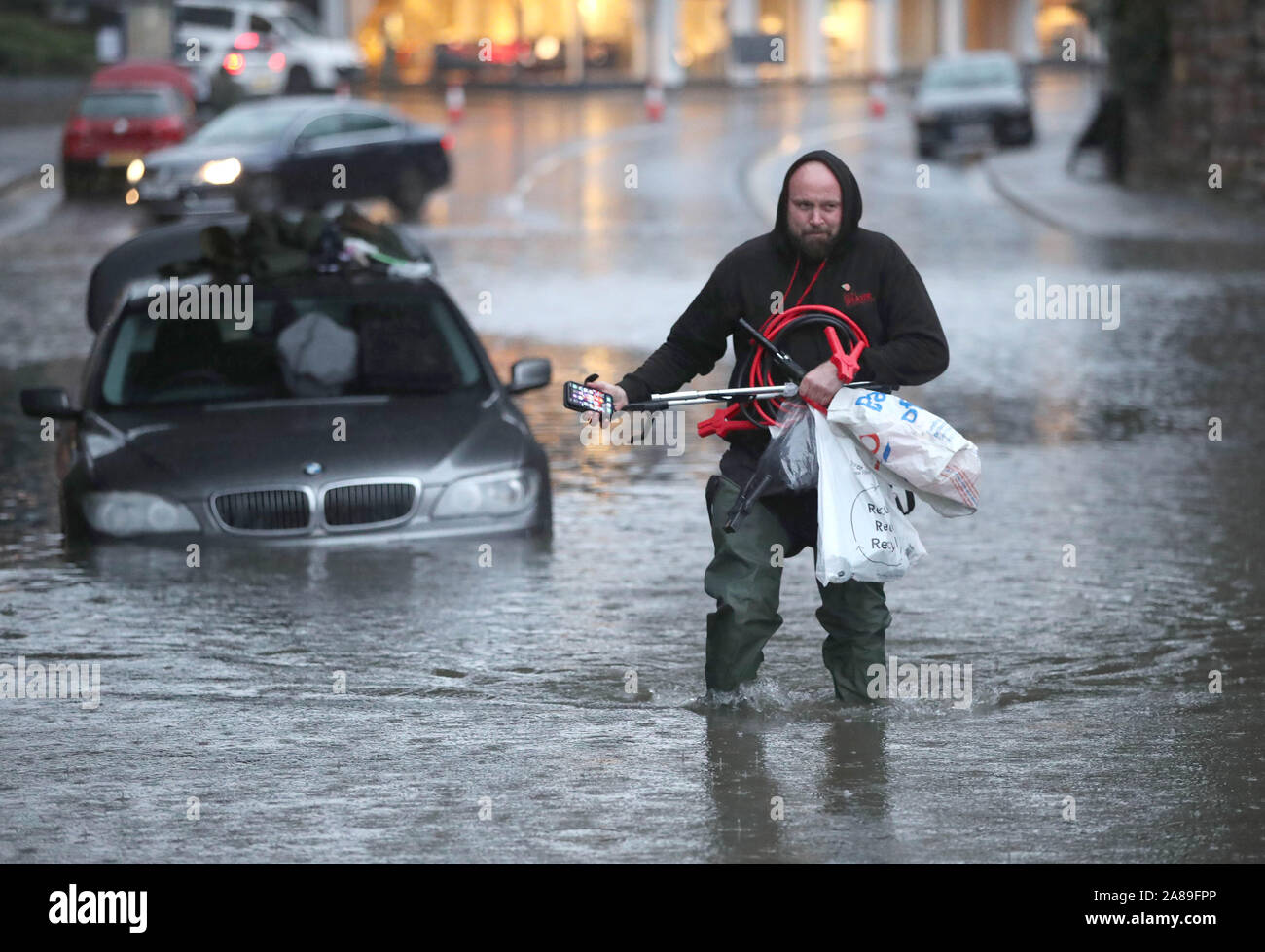 A man wades through a flooded street Sheffield, after torrential rain in the area. Stock Photo