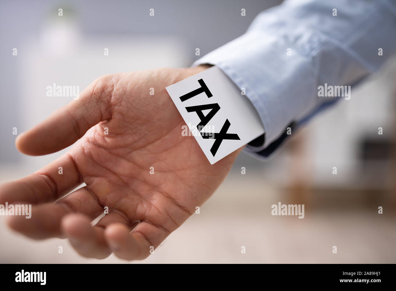 Close-up Of Businessperson Showing Unfair Tax Advantage In His Sleeve Stock Photo