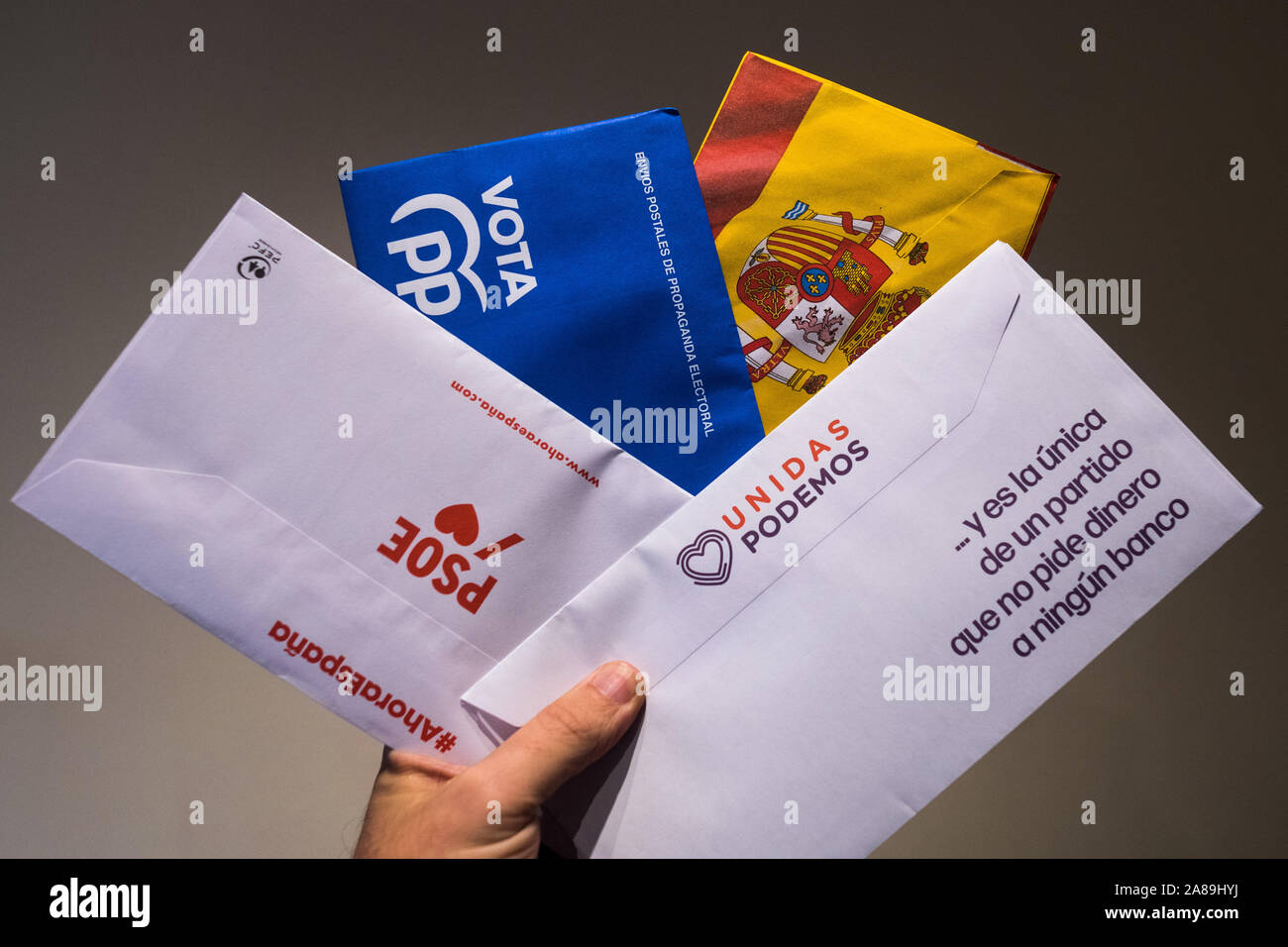 Madrid, Spain, November 7, 2019. A hand of a man showing postal mail of some of the main Spanish political parties (PSOE, PP, VOX, Unidas Podemos) that contains the ballots to vote in the next general elections that will take place on November 10 in Spain. Credit: Marcos del Mazo/Alamy Live News Stock Photo