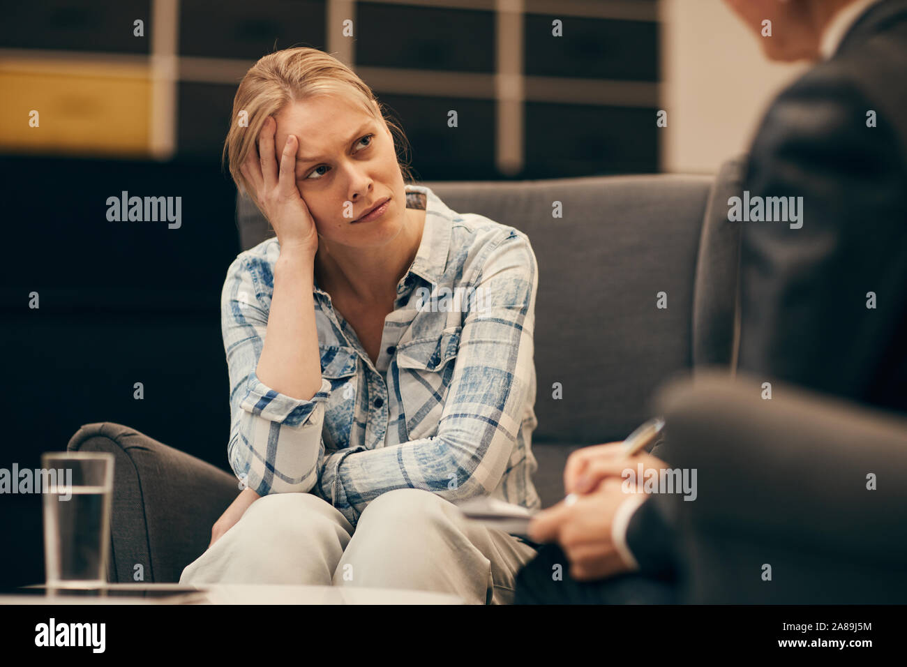 Young woman has depression she sitting on sofa and talking to the psychologist at office Stock Photo