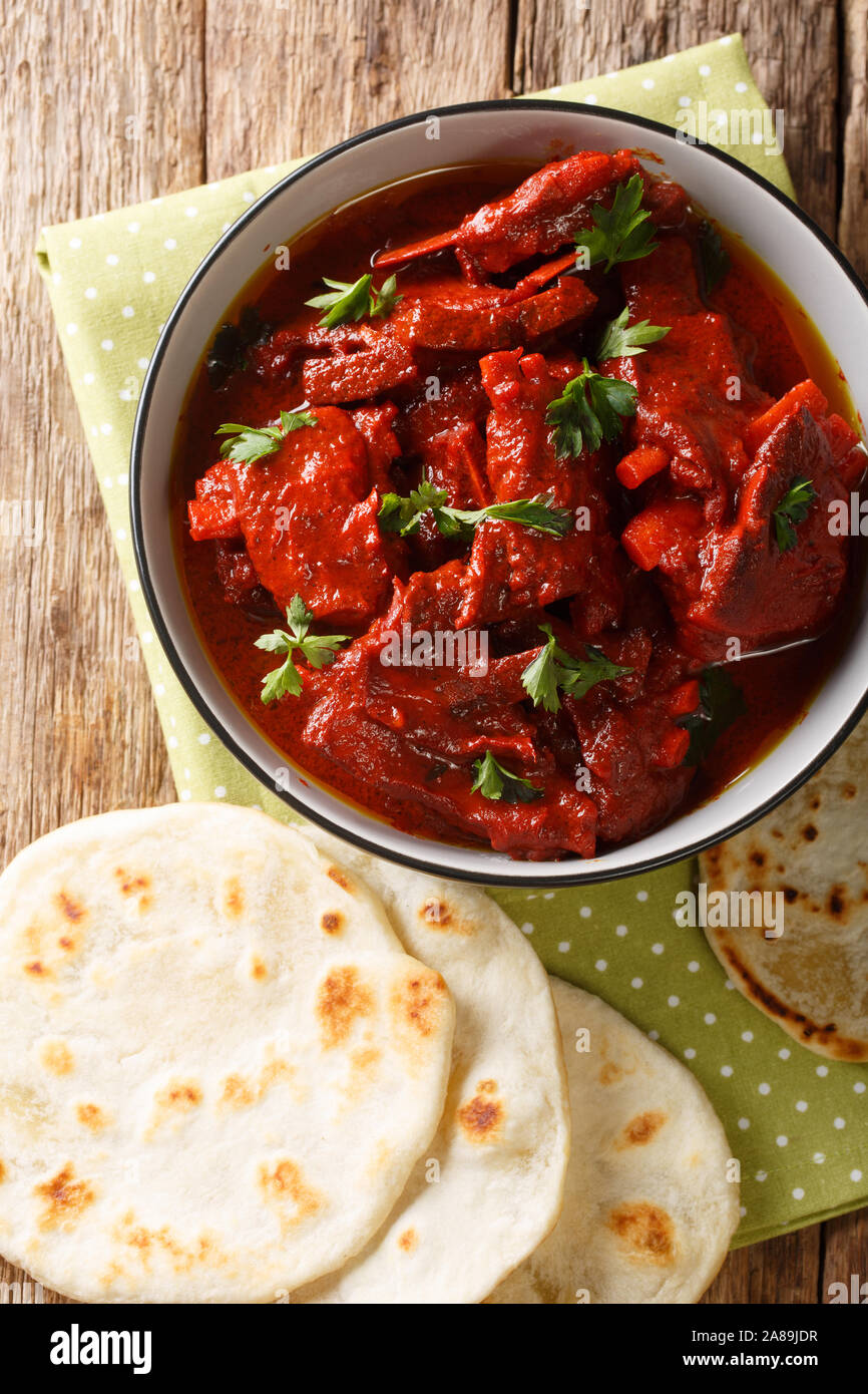 Rajasthani Jungli Maas is a traditional Indian meat dish served with roti close-up on the table. Vertical top view from above Stock Photo