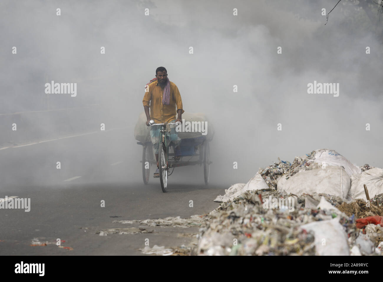 Narayanganj, Bangladesh. 7th Nov, 2019. A heap of garbage is set on fire causing air pollution and problems to the vehicle drivers at Narayanganj, near Dhaka, Bangladesh, November 7, 2019. Unregulated trash burning around the city is pumping far more pollution into the atmosphere than shown by official records. Atmospheric Research estimates that more than 40% of the garbage is burned in such fires, emitting gases and particles that can substantially affect human health and climate change. Credit: Suvra Kanti Das/ZUMA Wire/Alamy Live News Stock Photo