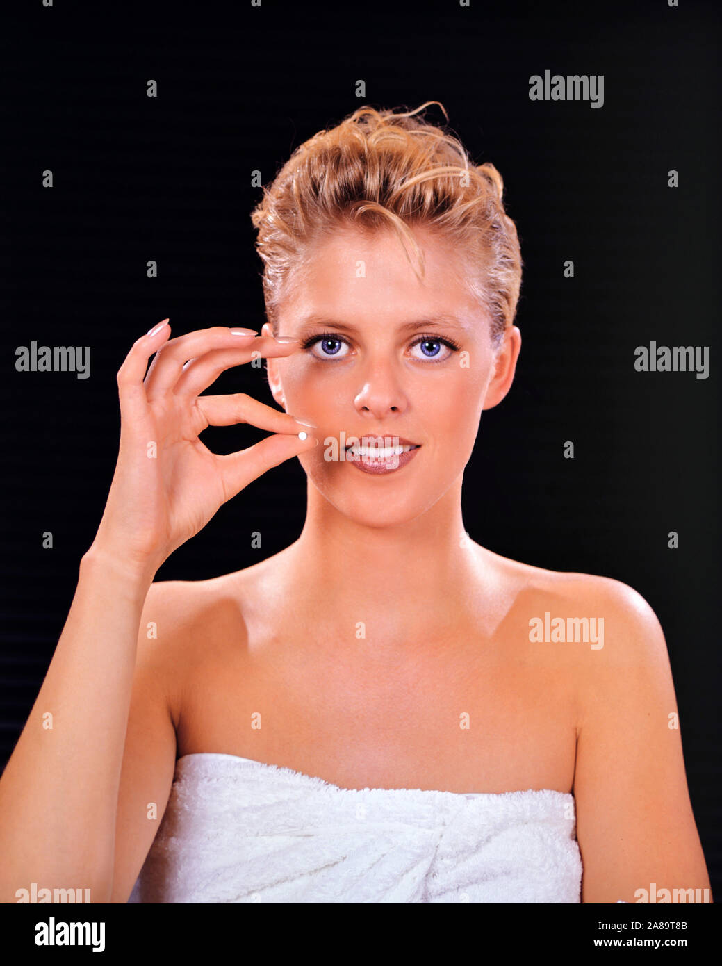 Blonde Frau mit Anti Baby Pille, Tablette, MR: Yes Stock Photo