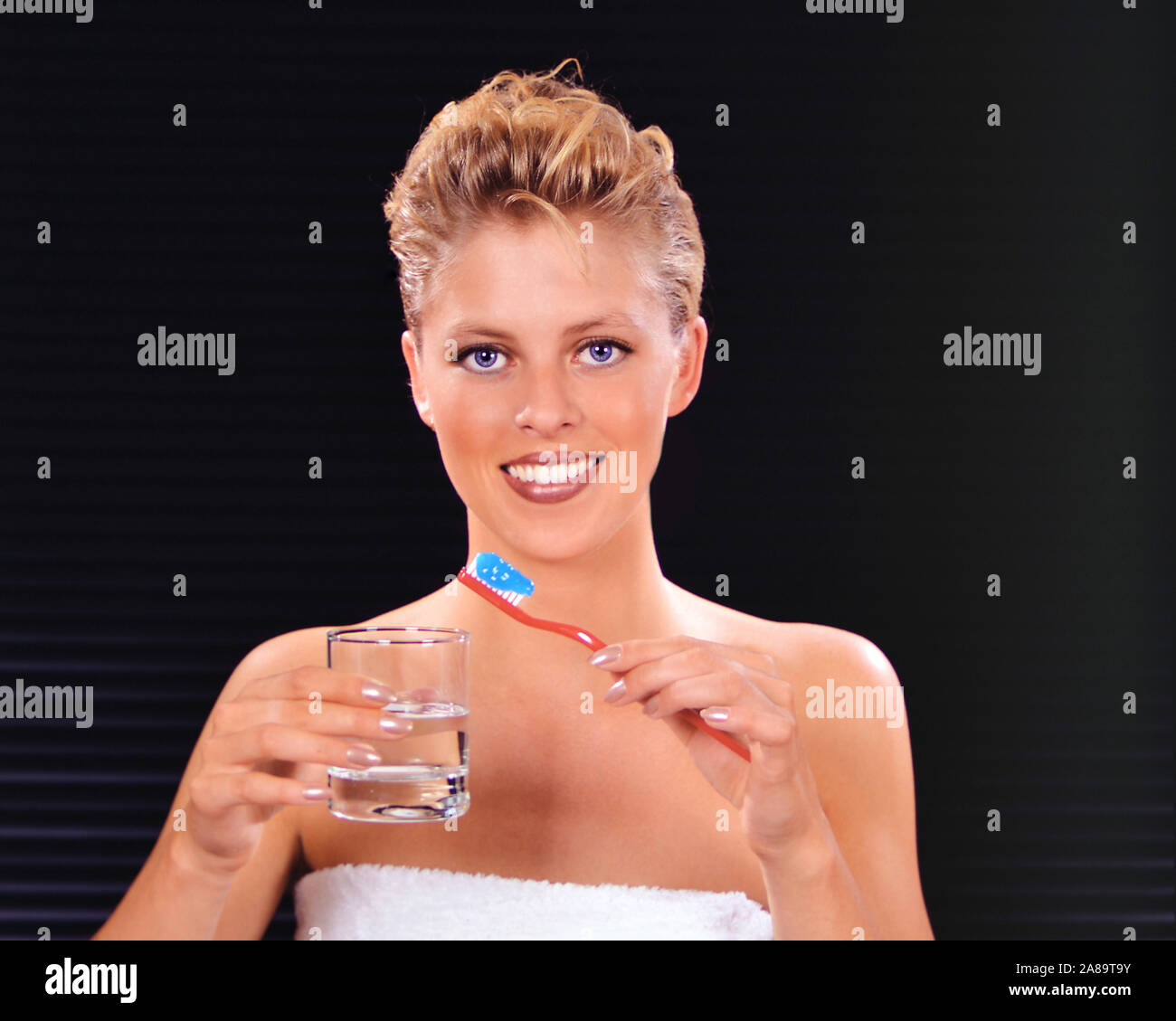 Junge blonde Frau reinigt ihre Zähne mit einer Zahnbürste, Zähne putzen, MR: Yes Stock Photo