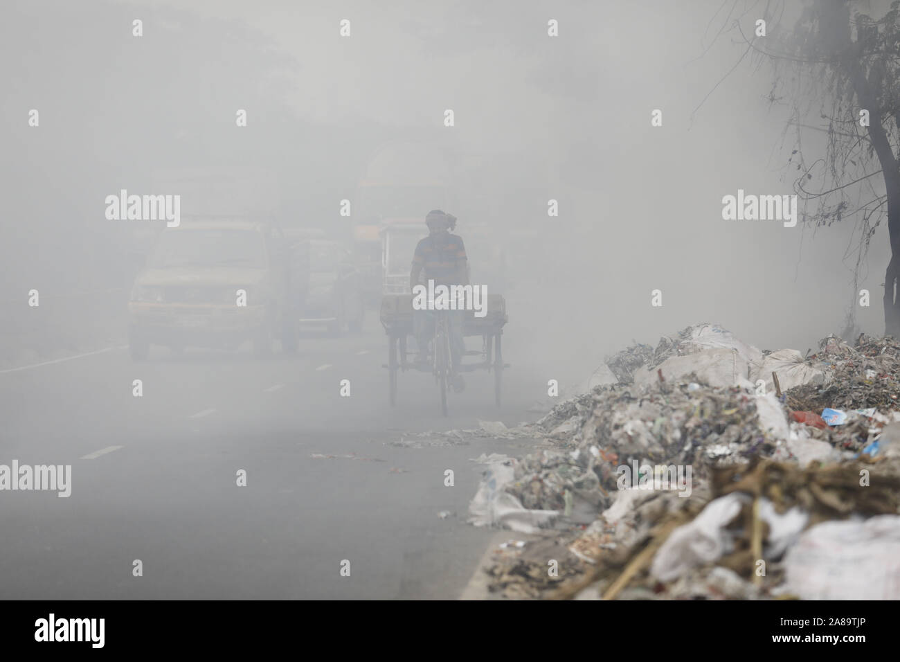 Narayanganj, Bangladesh. 7th Nov, 2019. A heap of garbage is set on fire causing air pollution and problems to the vehicle drivers at Narayanganj, near Dhaka, Bangladesh, November 7, 2019. Unregulated trash burning around the city is pumping far more pollution into the atmosphere than shown by official records. Atmospheric Research estimates that more than 40% of the garbage is burned in such fires, emitting gases and particles that can substantially affect human health and climate change. Credit: Suvra Kanti Das/ZUMA Wire/Alamy Live News Stock Photo
