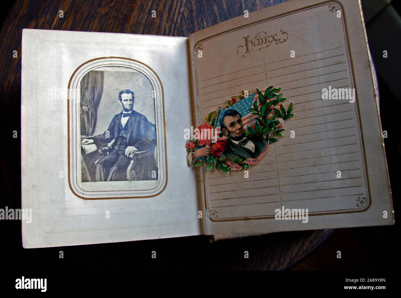 Vintage photo album circa late 1800s with a photograph of President Abraham Lincoln and a colorful cutout illustration of Lincoln. Stock Photo