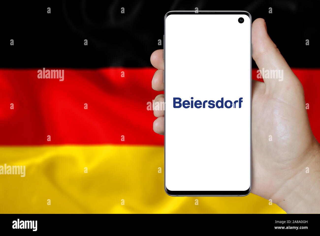 Logo of public company Beiersdorf displayed on a smartphone. Flag of Germany background. Credit: PIXDUCE Stock Photo