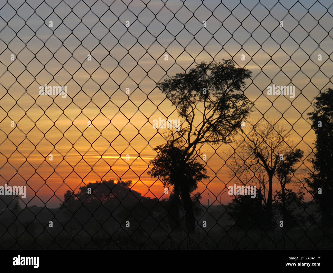 sunrise across the fence Stock Photo