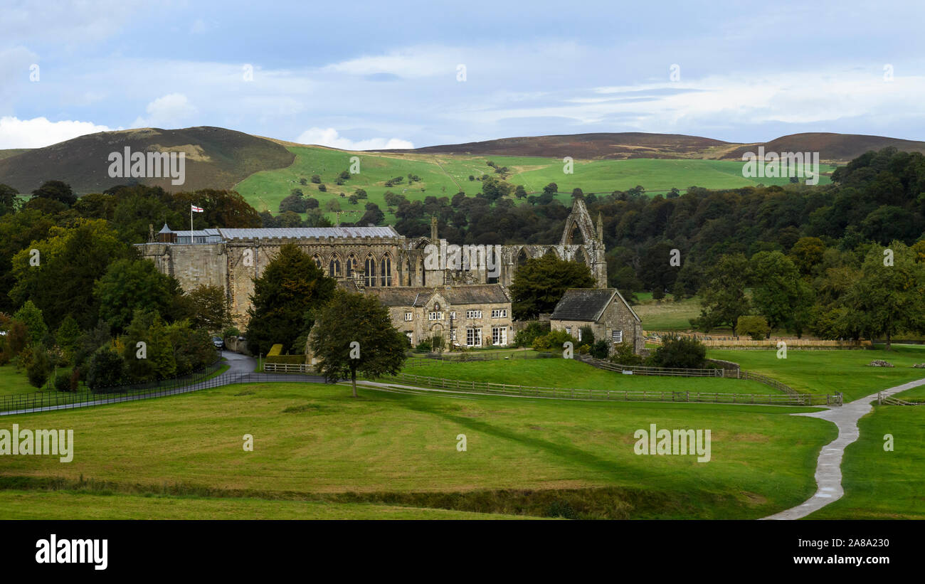 Scenic rural view over ancient, picturesque monastic ruins of Bolton Abbey, Priory Church, Old Rectory & winding path - Yorkshire Dales, England, UK. Stock Photo