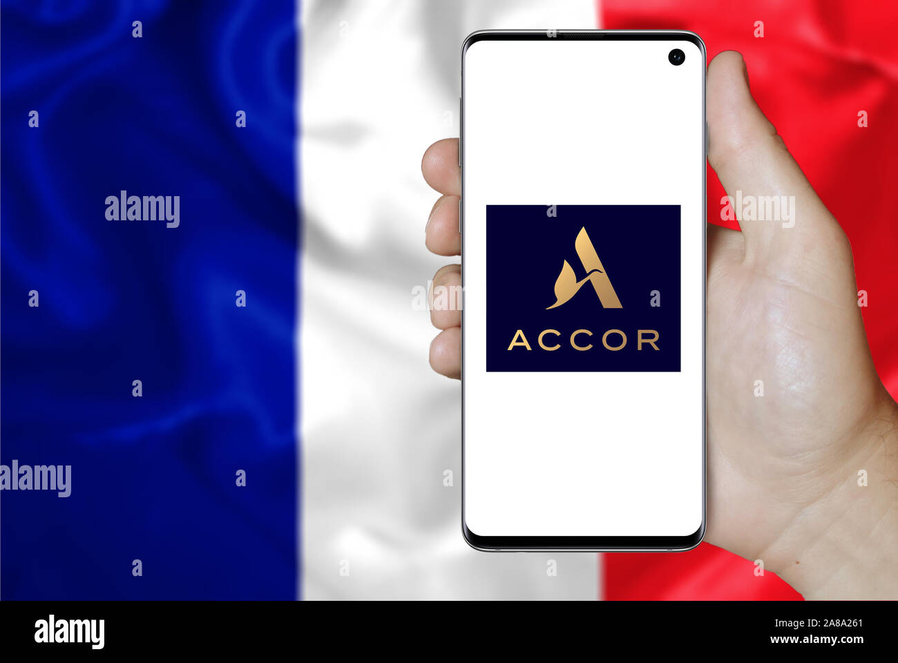 Logo of public company Accor displayed on a smartphone. Flag of France background. Credit: PIXDUCE Stock Photo