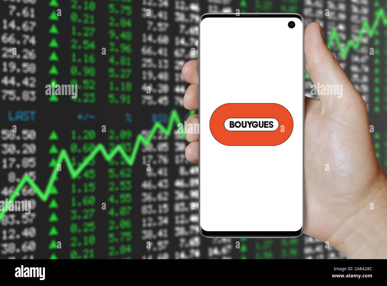 Logo of public company Bouygues displayed on a smartphone. Positive stock market background. Credit: PIXDUCE Stock Photo