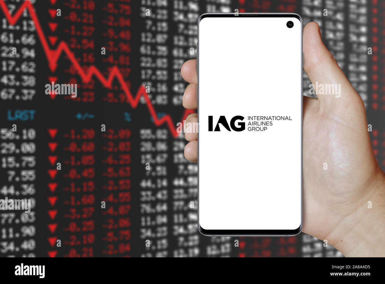 Logo of public company International Airlines Group displayed on a smartphone. Negative stock market background. Credit: PIXDUCE Stock Photo