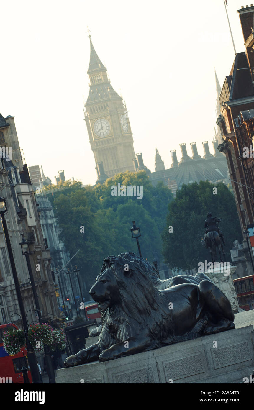 Trafalgar Square lions standing guard under a misty view of Big Ben on the horizon Stock Photo