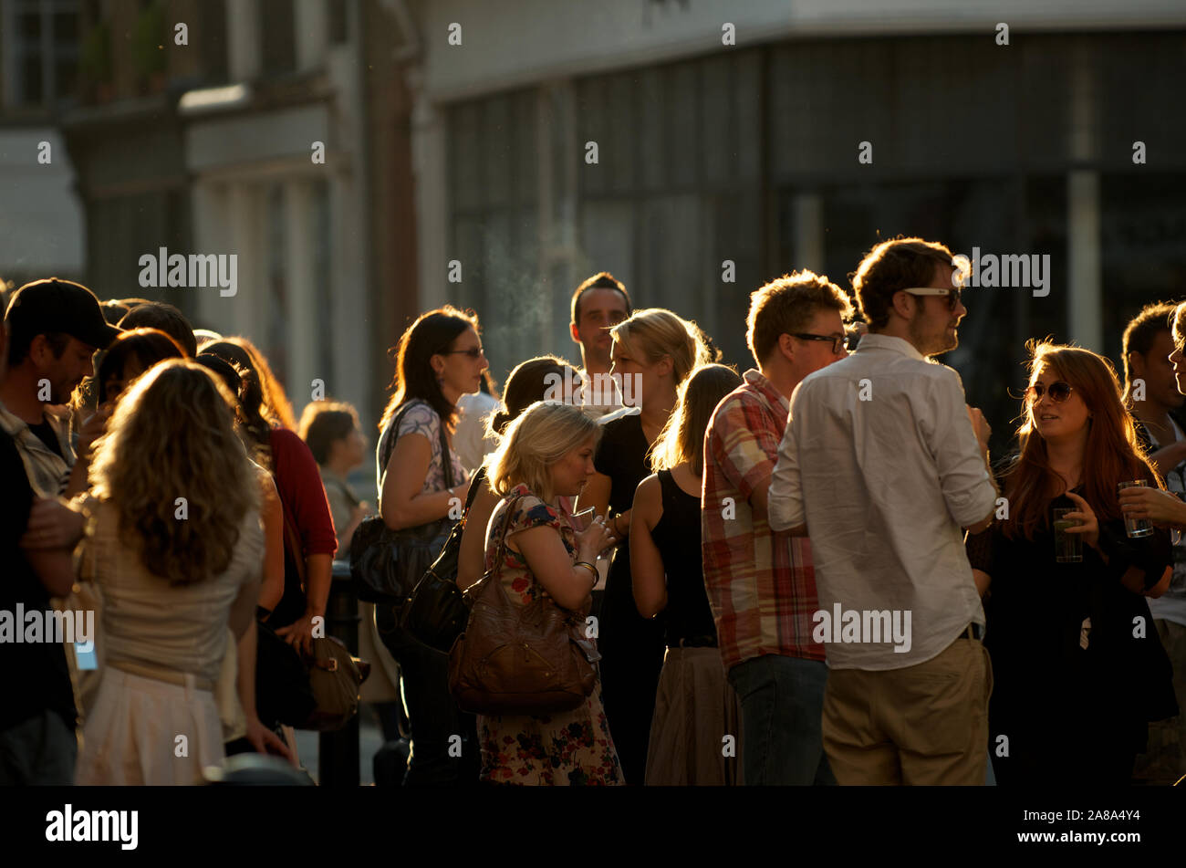 LONDON - SEPTEMBER 30, 2011: Group of young Londoners gather outside a pub in the last of the autumn afternoon sun. Stock Photo
