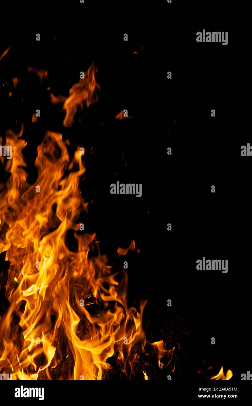Yellow flames licking the frame against a black night background Stock Photo