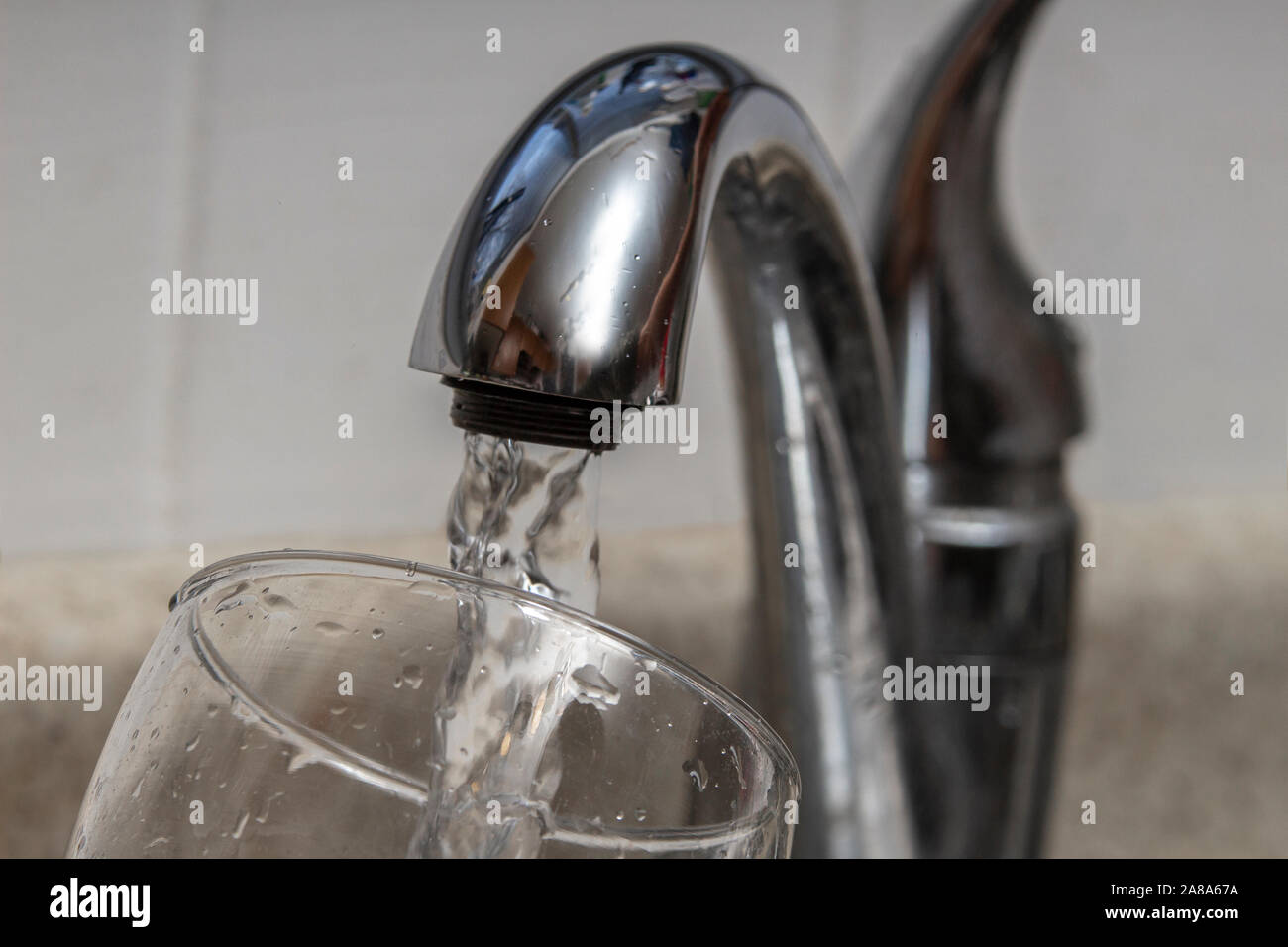Glass at water tap and filling water with lead contamination Stock Photo