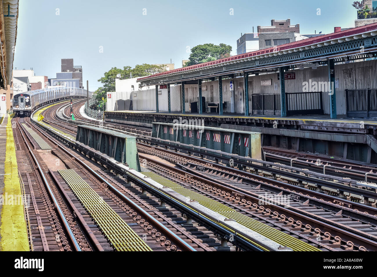 Train arriving at the station in New York City. Buildings in the background, cityscape. Travel and transit concept. Manhattan, NYC, USA. Stock Photo