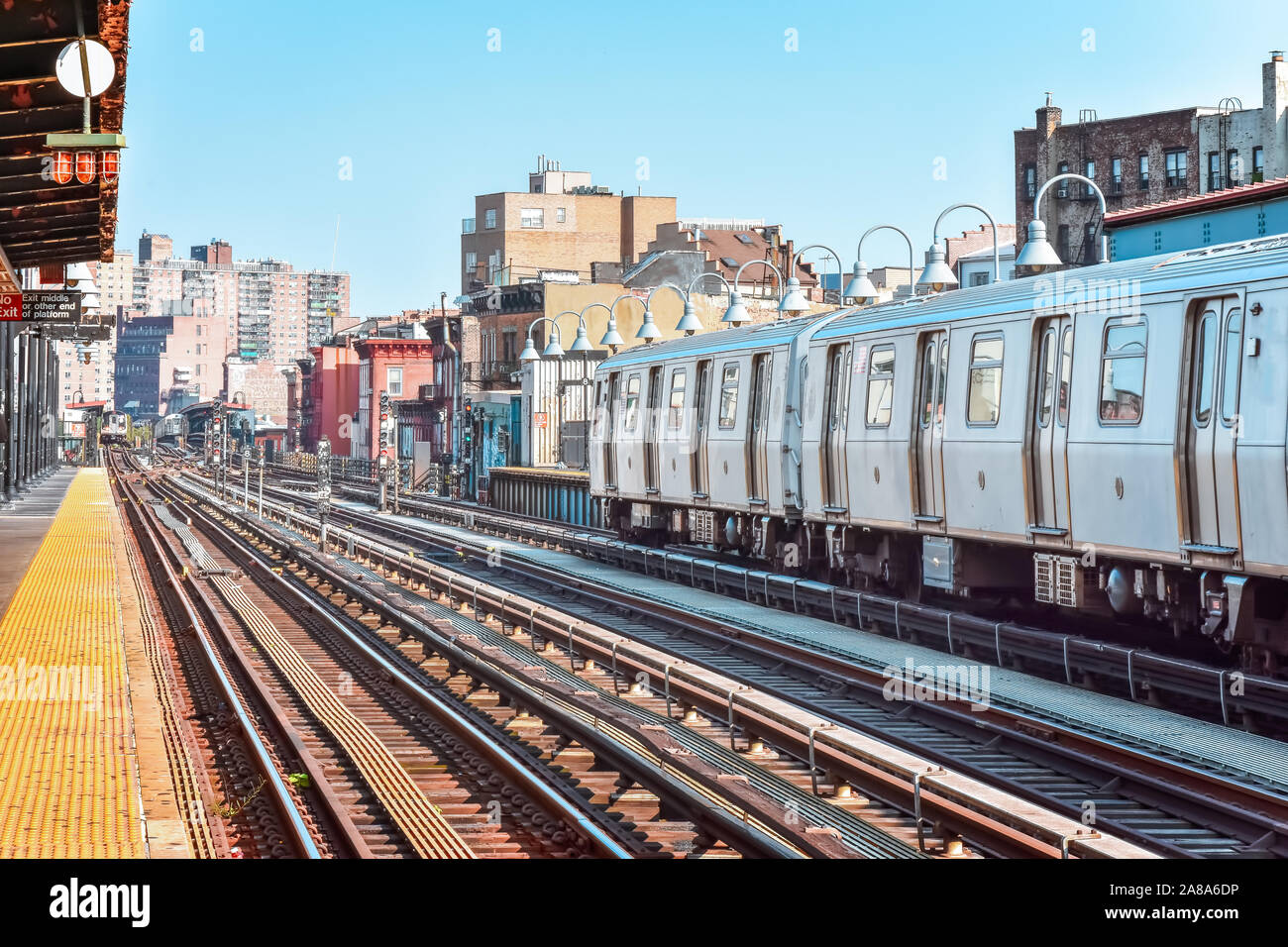 Train arriving at the station in New York City. Buildings in the background, cityscape. Travel and transit concept. Manhattan, NYC, USA. Stock Photo