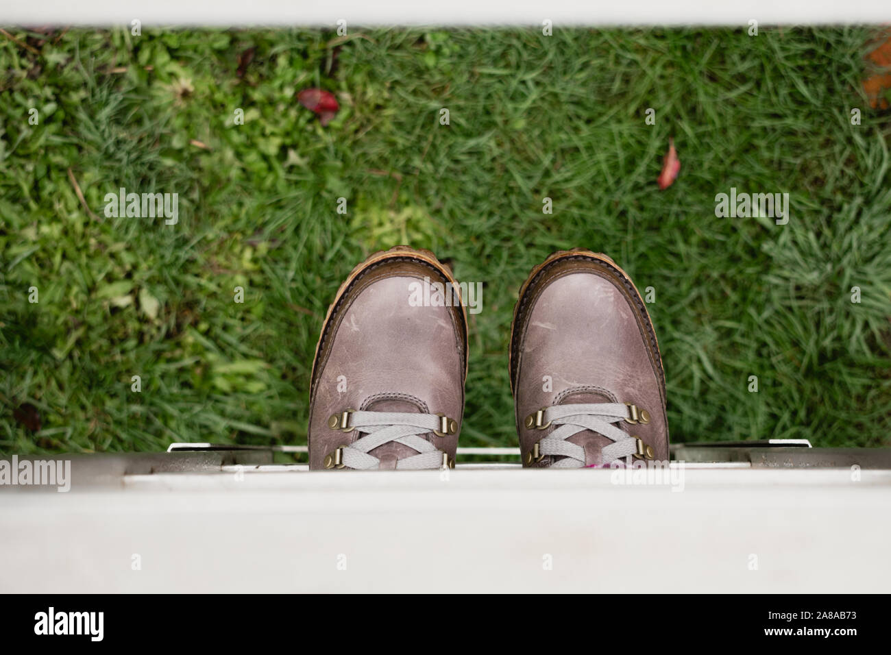 Woman on ladder wearing lace-up boots, view from above, shallow depth of field, MR Stock Photo