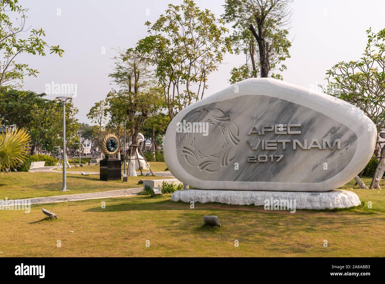 Da Nang, Vietnam - March 10, 2019: Memorial Park. Gray marble framed by shite stone statue in honor of 2017 APEC conference in green park environment Stock Photo