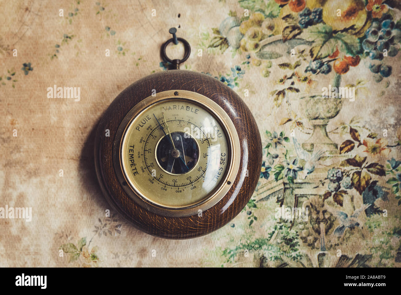 Dusty vintage barometer in old house, the writing is in french Stock