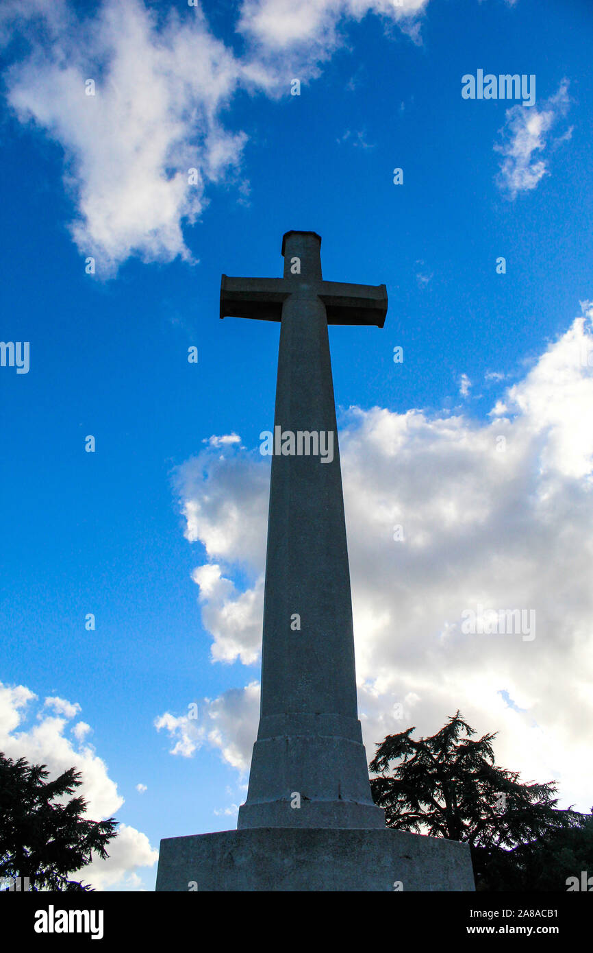 A cross of sacrifice in France against a blue sky with fluffy clouds. Stock Photo