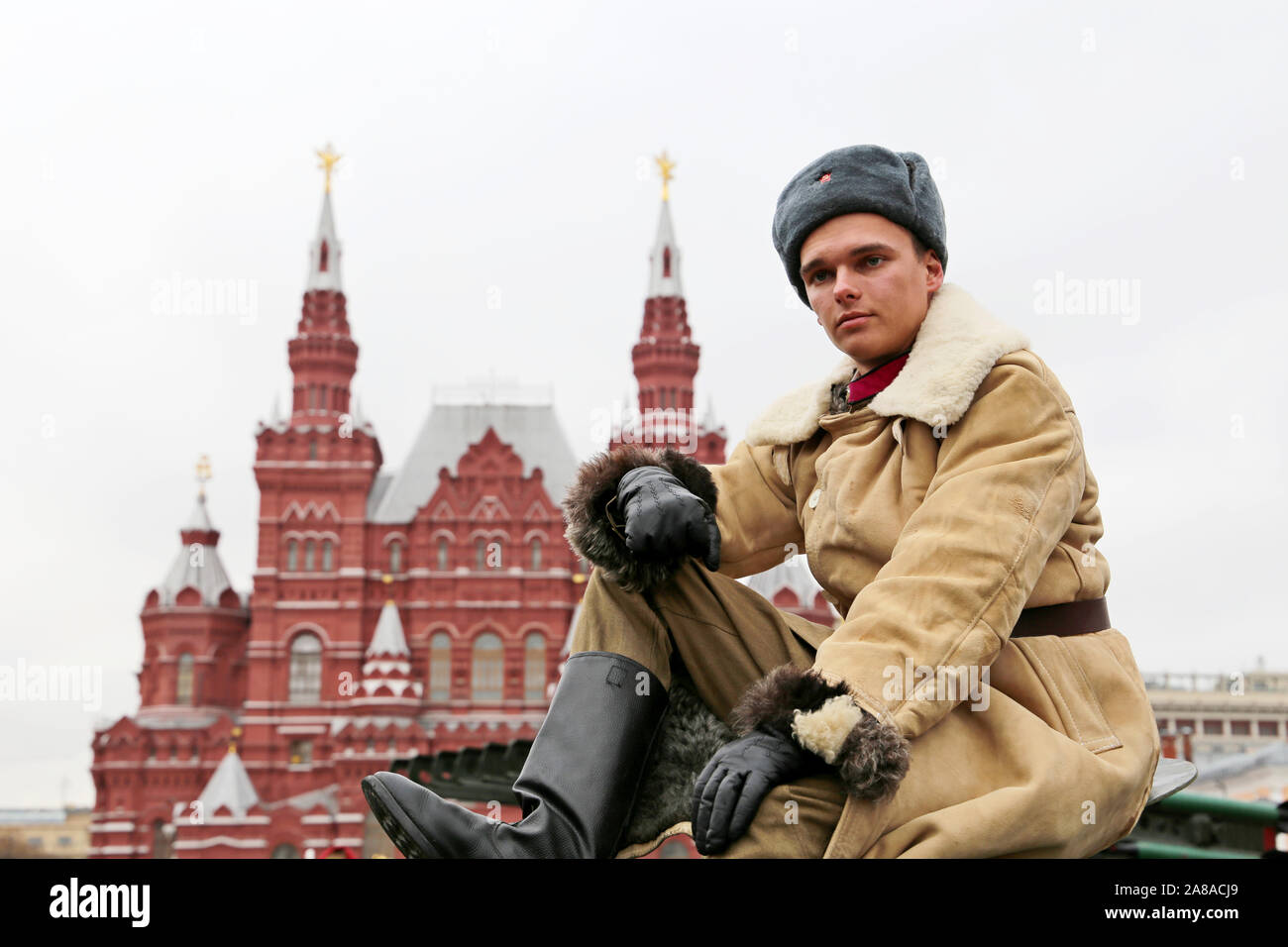Man in Soviet military uniform of tankman sitting on the hatch of russian tank during a historic parade on Red square. Concept for 23 February Stock Photo
