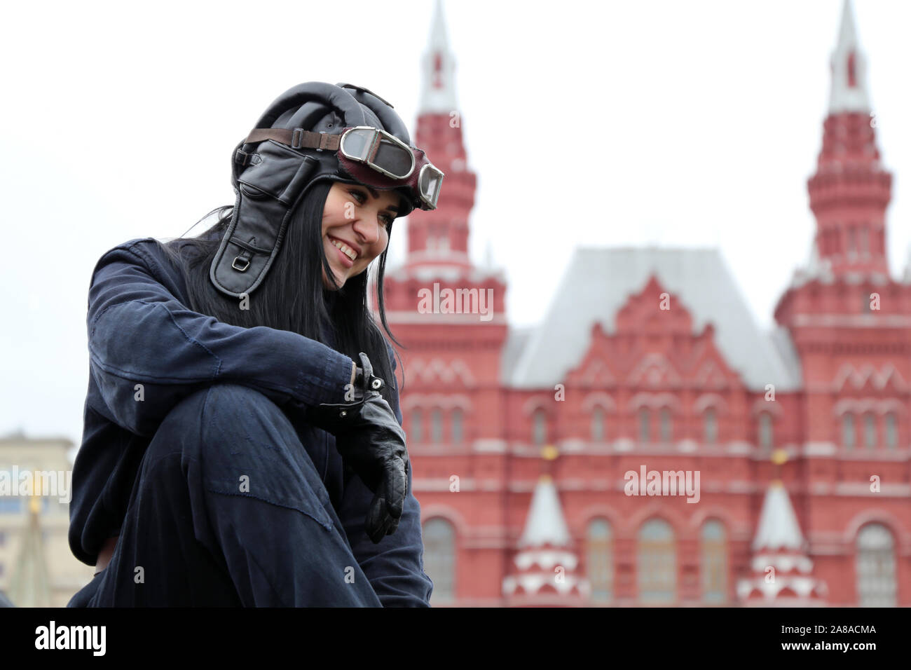 Happy girl in military uniform of tankman sitting on the hatch of russian tank during a historic parade on Red square Stock Photo