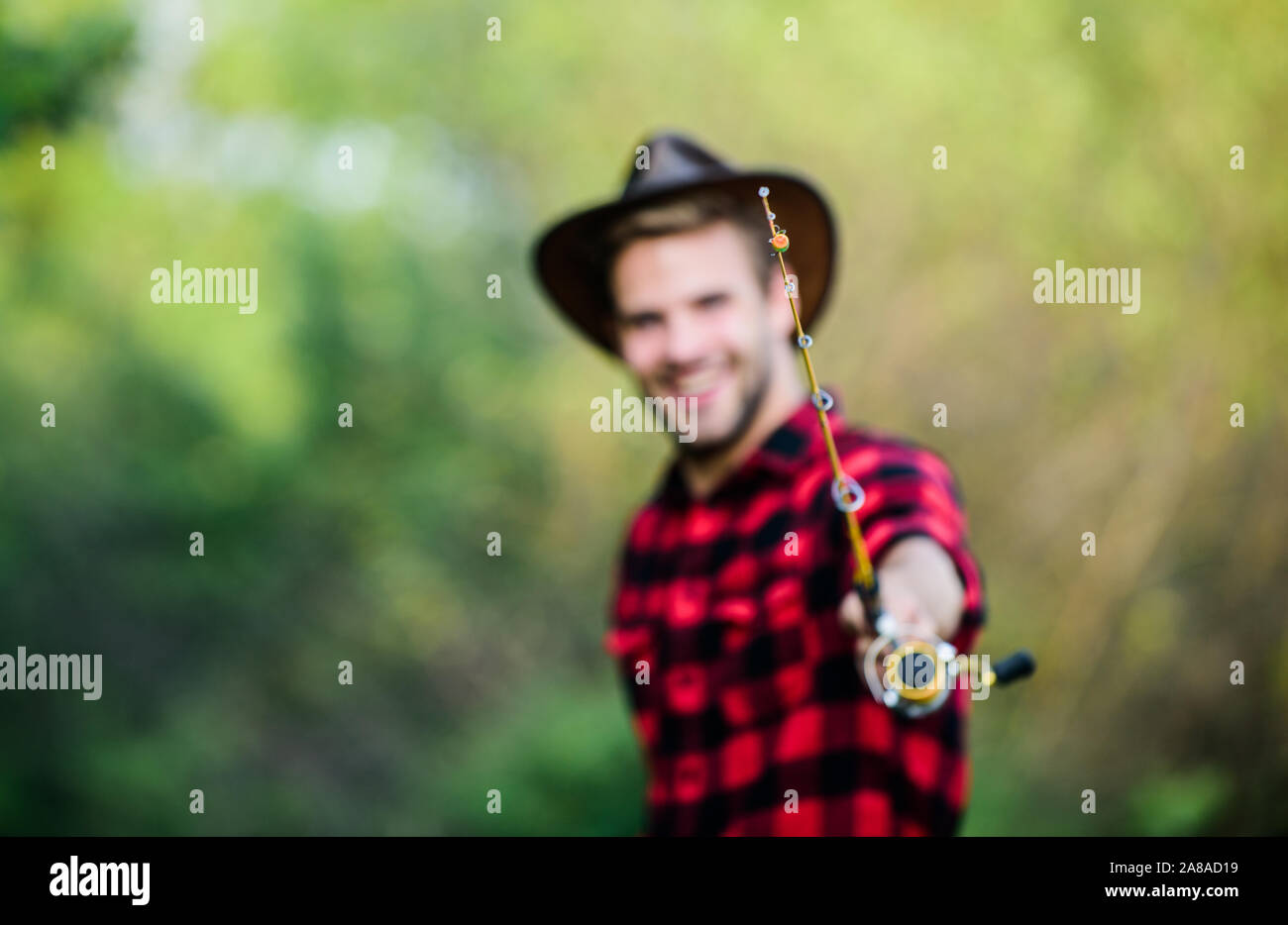 fishing rod selective focus. happy fisherman in hat blurred. western  portrait. Vintage style man. Wild West retro cowboy. fly fishing. man  checkered shirt on ranch. fisher hold fish net. hobby Stock Photo -