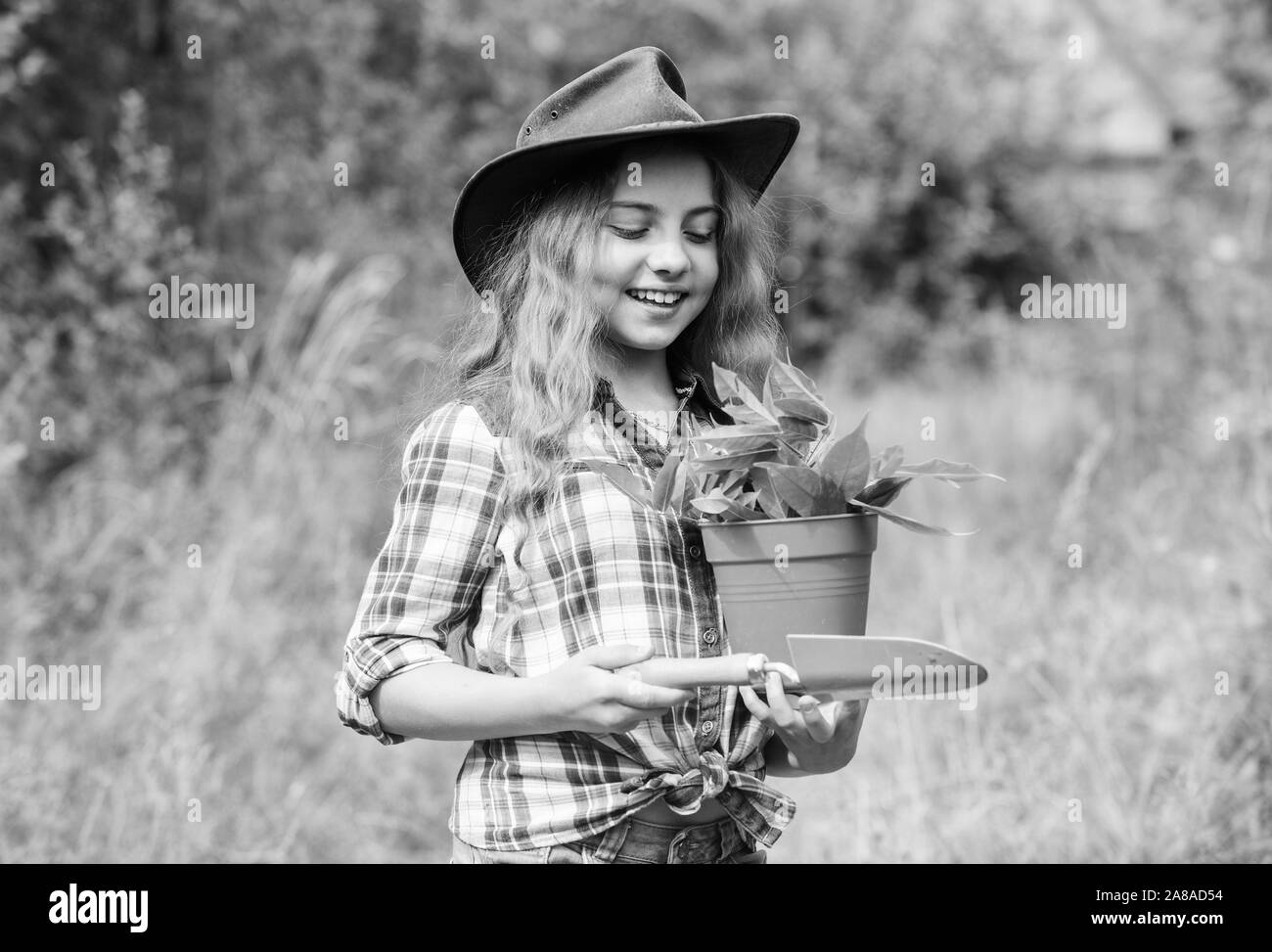 Green life. small girl farmer care about plant in pot. farming and agriculture. spring season