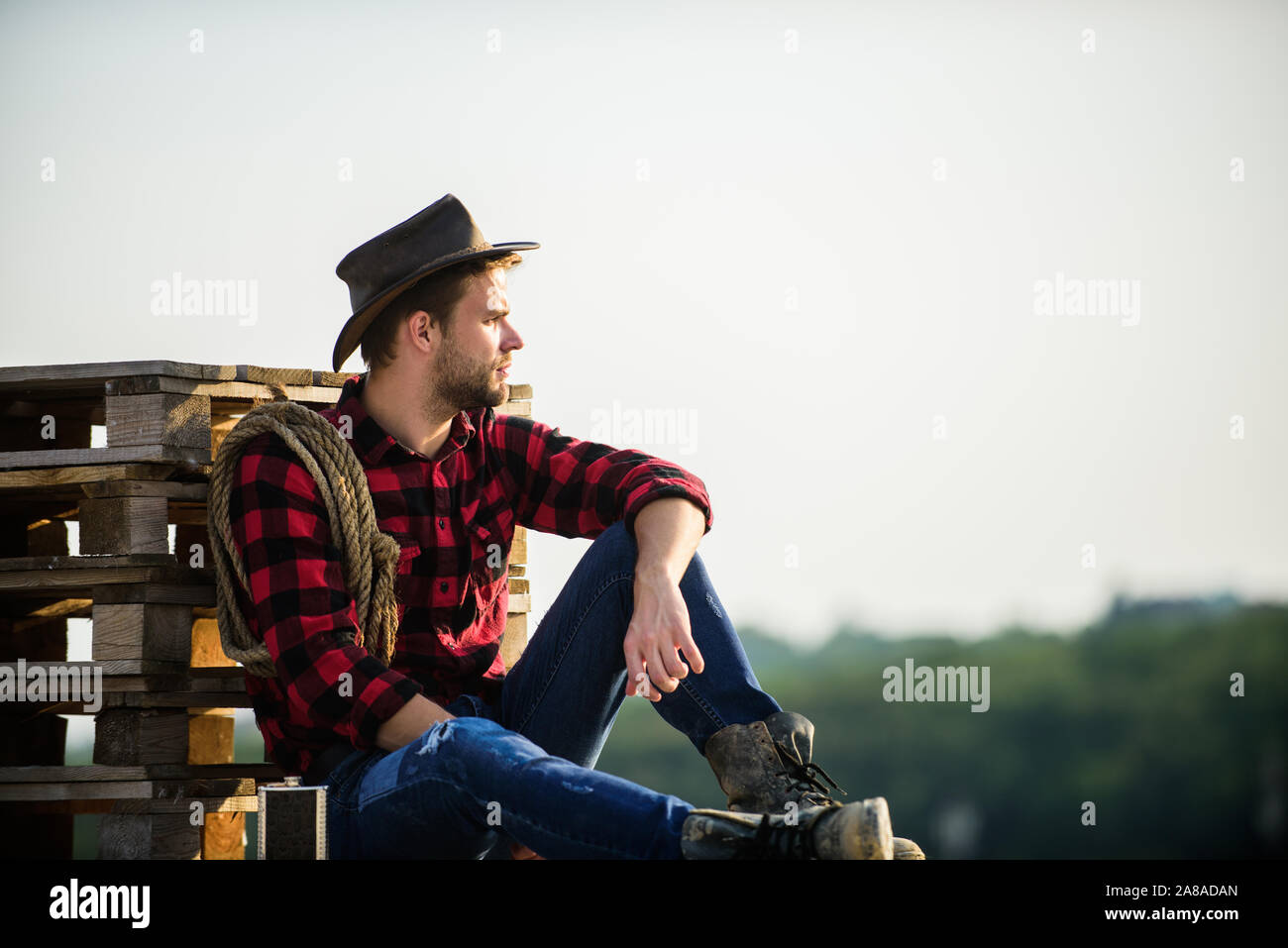 Farmer cowboy handsome man relaxing after hard working day at ranch ...