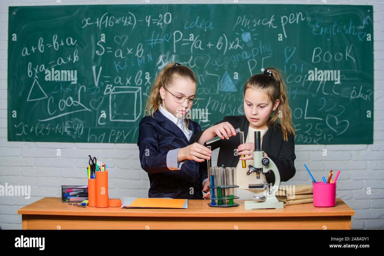Chemistry research. Children using microscope. Little girls in school lab. Microscope. Biology lesson. Checking the results. Little scientist work with microscope. science experiments in laboratory. Stock Photo