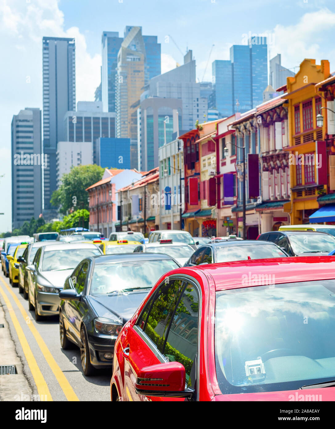 Car traffic, colorful shophouses along street by Neil Road, Singapore modern metropolis skyline Stock Photo
