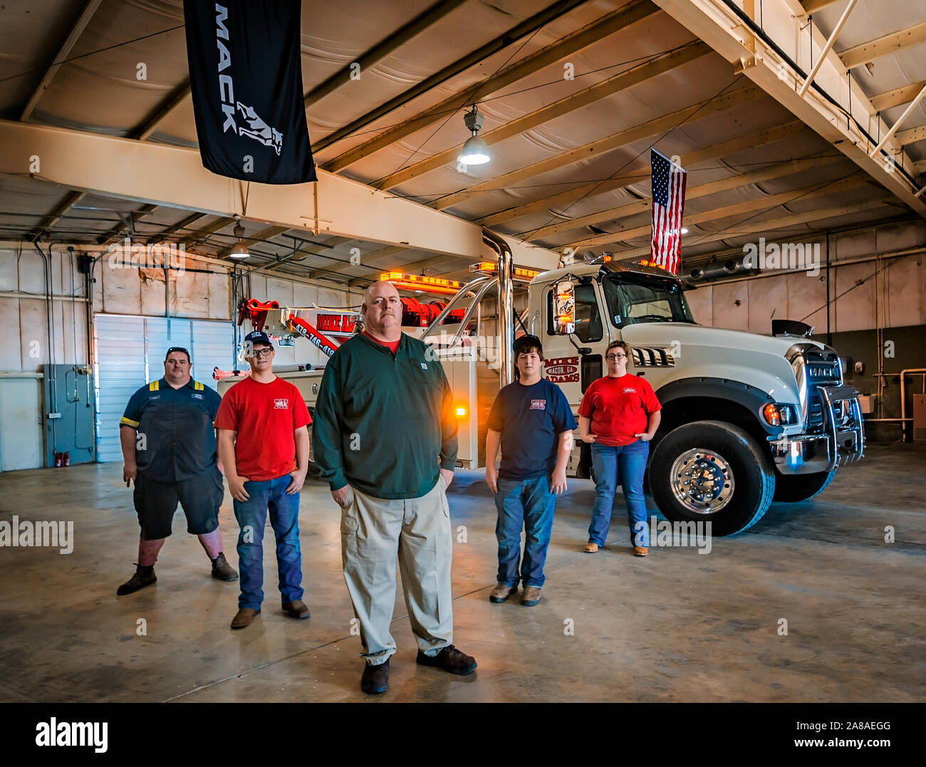 Mike Adams, of Mike Adams Towing and Air Cushion Recovery, poses with his children beside his newest truck, a 2016 Mack Granite. Stock Photo