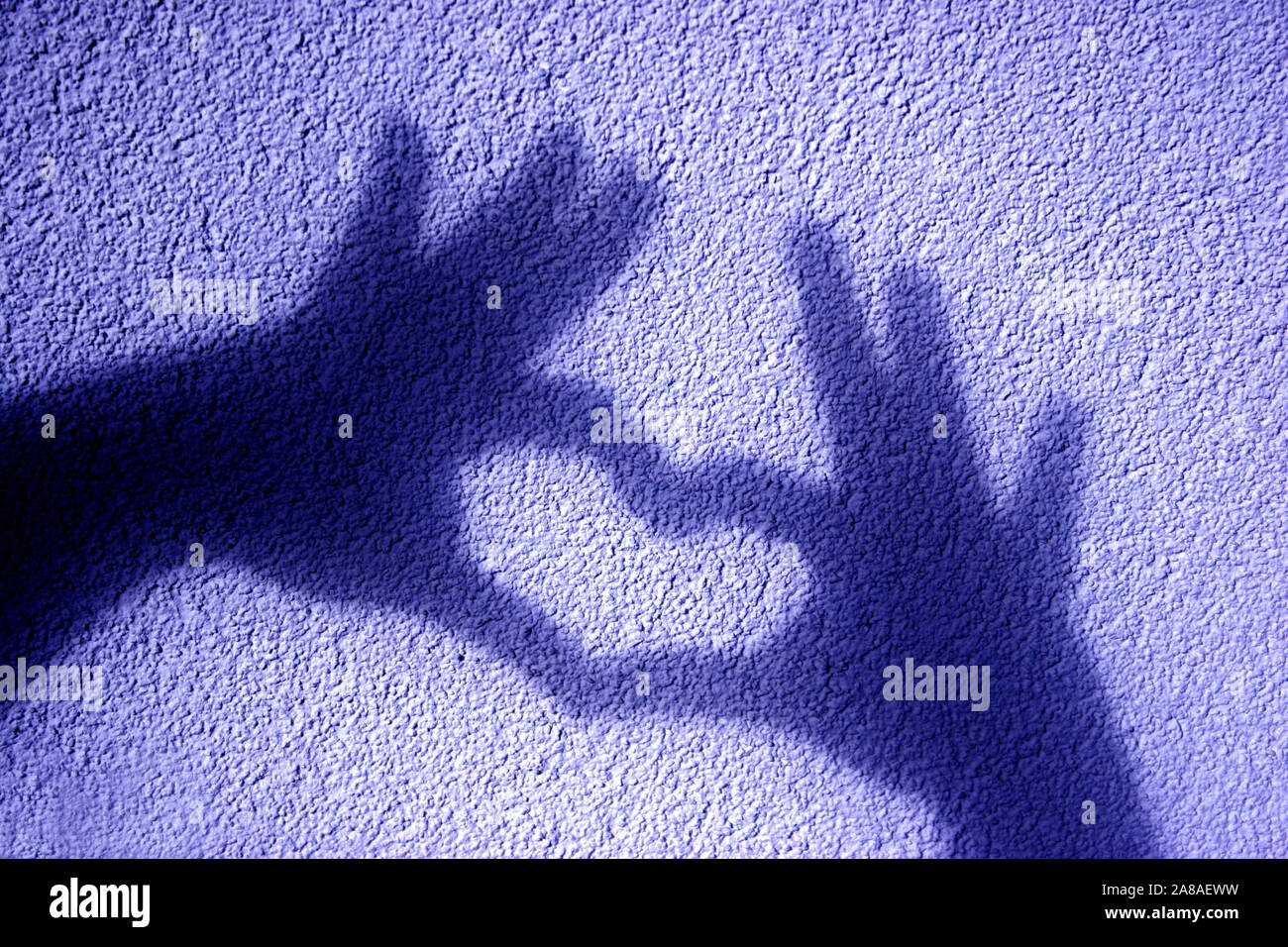 Schattenspiel, Schatten zweier Hände formen ein Herz auf eine Mauer, Stock Photo