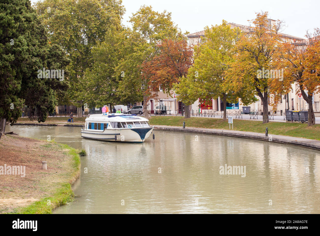 Family people driving a pleasure boat on the Canal du Midi in the French town of Carcassonne France during Autumn Stock Photo